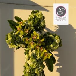 Cross-shaped floral tribute with green orchids and hydrangeas on a stand