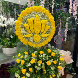 Large yellow floral standing tribute with a lotus design and roses below