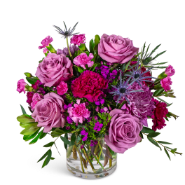 Lavender roses and pink mixed flowers in a clear glass vase