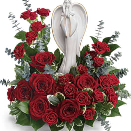 Red roses arranged around a white angel statue