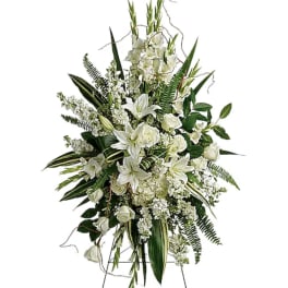 Tall white floral standing spray with lilies and roses on an easel