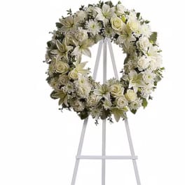 White floral wreath on a tall metal easel