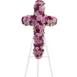 Purple and pink floral cross on a white stand