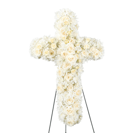White floral cross-shaped standing arrangement on an easel
