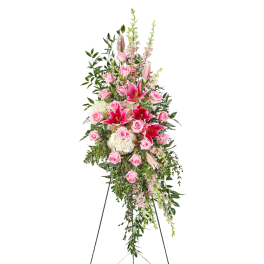 Tall standing floral spray with pink roses and lilies on an easel