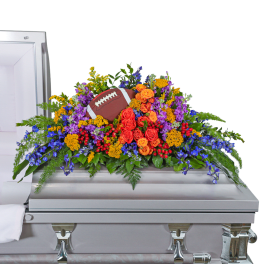 Colorful floral casket spray with a football centerpiece