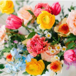 Colorful mixed bouquet with yellow, pink, peach, and blue flowers