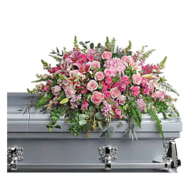 Pink floral casket spray on a silver casket