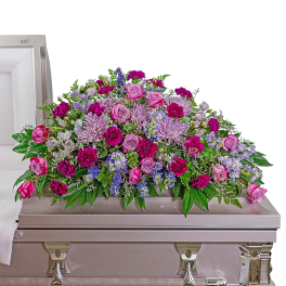 Pink and purple floral casket spray with roses and carnations