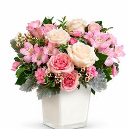 Pink and white rose bouquet in a square glass vase