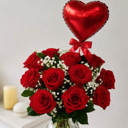Red roses in a glass vase with a red heart balloon
