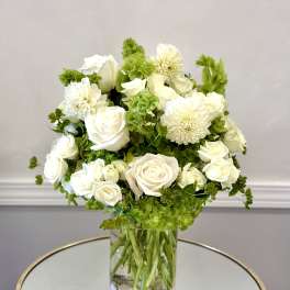 White roses and dahlias arranged in a clear glass vase
