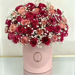 Bouquet of pink and red roses with baby's breath in a pink box