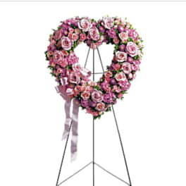 Pink rose funeral wreath on a standing easel with ribbon