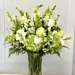 White and green bouquet in a clear glass vase