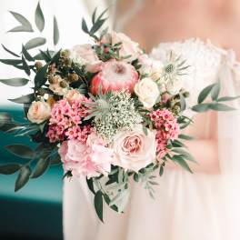 Bride holding a pastel bouquet with pink and cream flowers