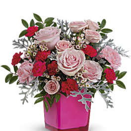 Pink roses and carnations in a magenta vase