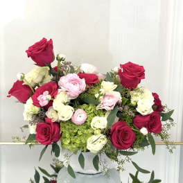 Pink and white roses with ranunculus in a white vase