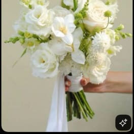 White bridal bouquet with roses and orchids tied with a ribbon