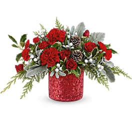 Red floral arrangement in a glittery red container with pinecones