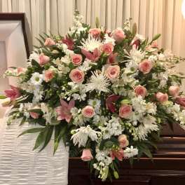 Large pink and white floral spray on a casket