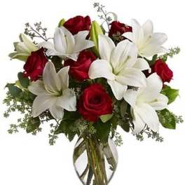 Bouquet of red roses and white lilies in a clear glass vase