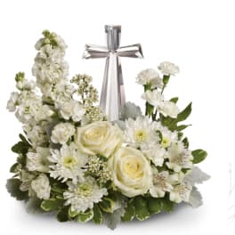 White floral arrangement with a silver cross centerpiece