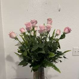 Pink roses arranged in a tall ribbed glass vase