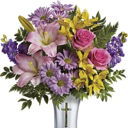 Mixed bouquet of pink, purple, and yellow flowers in a silver vase