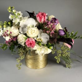 Mixed bouquet in a gold vase with pink, white, and purple flowers
