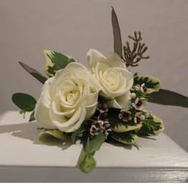 Small arrangement of two ivory roses with accent blooms and foliage