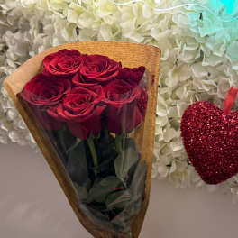 Bouquet of red roses wrapped in brown paper with a red ribbon