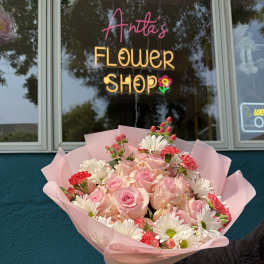 Pink rose bouquet with white daisies and red carnations in pink wrap