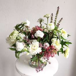 Mixed white and pink flowers arranged in a clear glass vase