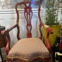 Red upholstered accent chair with carved wood frame