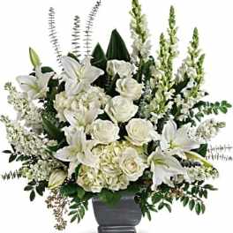 White lilies and roses arranged in a dark vase