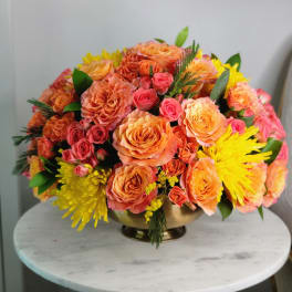 Peach and pink rose bouquet in a gold bowl vase