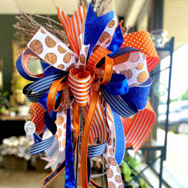 Decorative ribbon bow in blue, orange, and white with basketball patterns