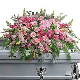 Pink floral casket spray with roses and lilies