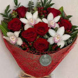 Bouquet of red roses and white orchids wrapped in red mesh