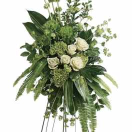 Tall white rose standing spray with lush greenery on an easel
