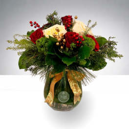 Bouquet of red and white roses in a glass vase with gold ribbon