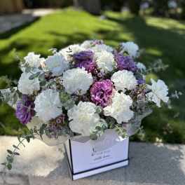 Bouquet of white and purple carnations in a gift box