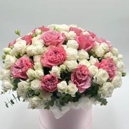 Pink and white roses arranged in a round pink box