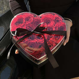 Heart-shaped box of red roses tied with a black ribbon