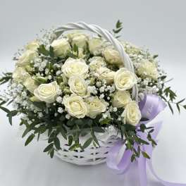 White rose bouquet in a white basket with a lavender ribbon
