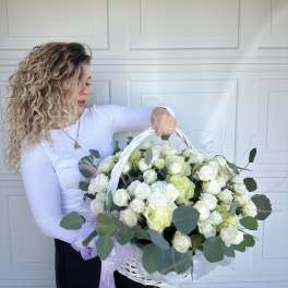 Large white basket of white and pale green roses with eucalyptus