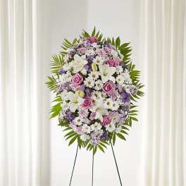 Standing floral wreath with white lilies, pink roses, and purple daisies