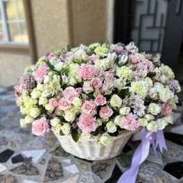 Large basket of pink and white flowers with a lavender ribbon