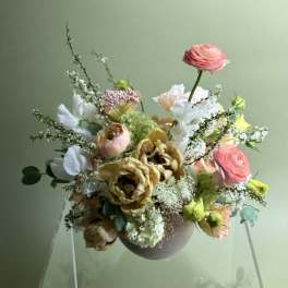 Mixed bouquet in a round vase with pink, white, and yellow blooms